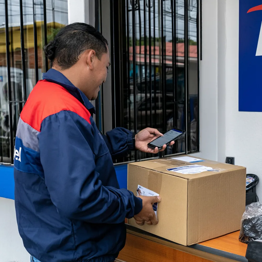 Mensajero de ParcelCR subiendo guía de encomienda desde la app en San José, Costa Rica